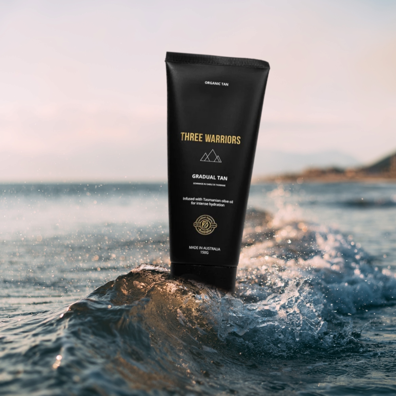 Pureday Et rør Gradual Tan 150 ml står på en lille bølge i havet med en rolig strand og klar himmel i baggrunden.