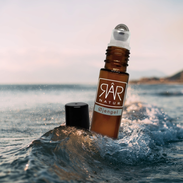 Pureday En hudpleje RAR Øjengel flaske med en rullekugle flyder på en bølge nær kysten, med havet og horisonten i baggrunden. Etiketten siger "Matas rar natur öljngel.