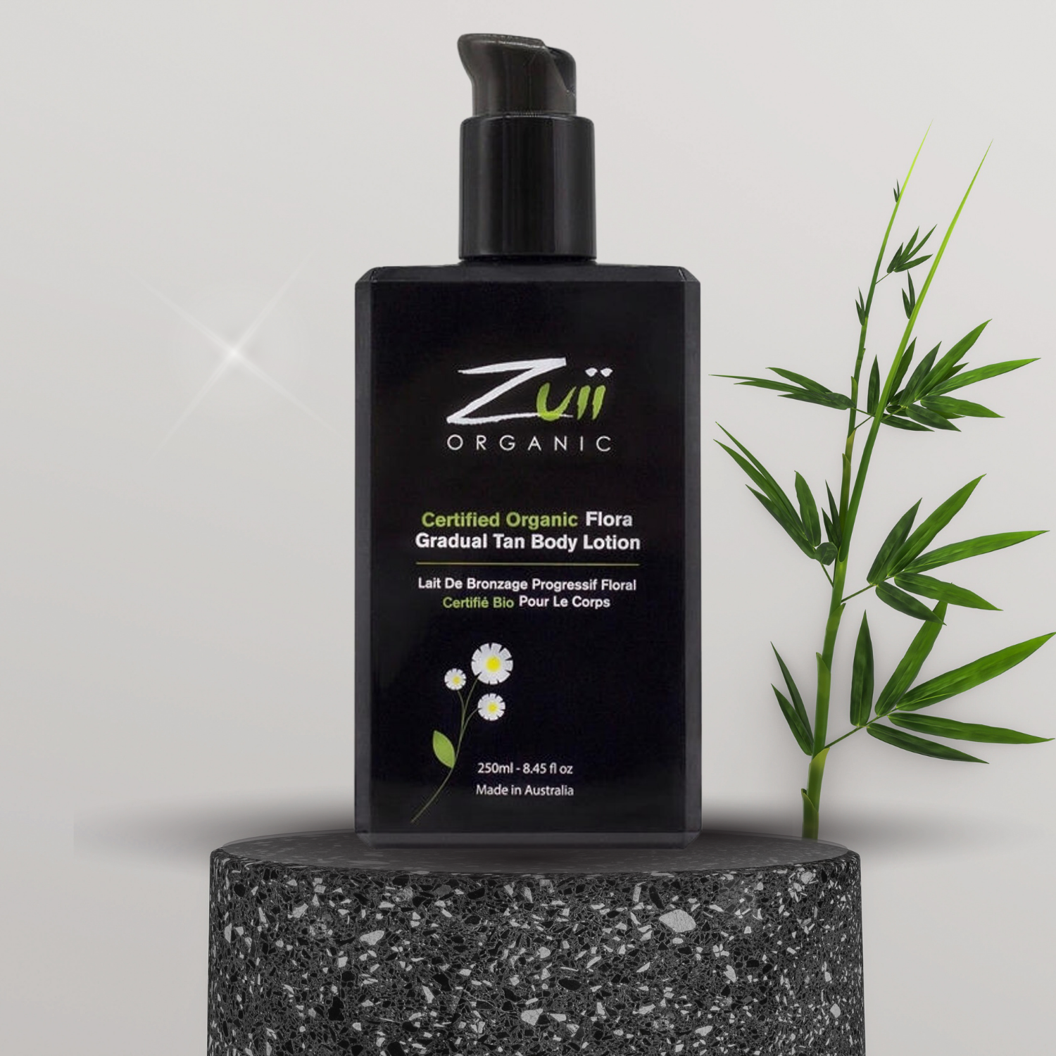 En flaske Zuii økologisk selvbruner Body Tan Lotion 250ml, der fremmer helbred og velvære, placeret ved siden af en bambusplante.