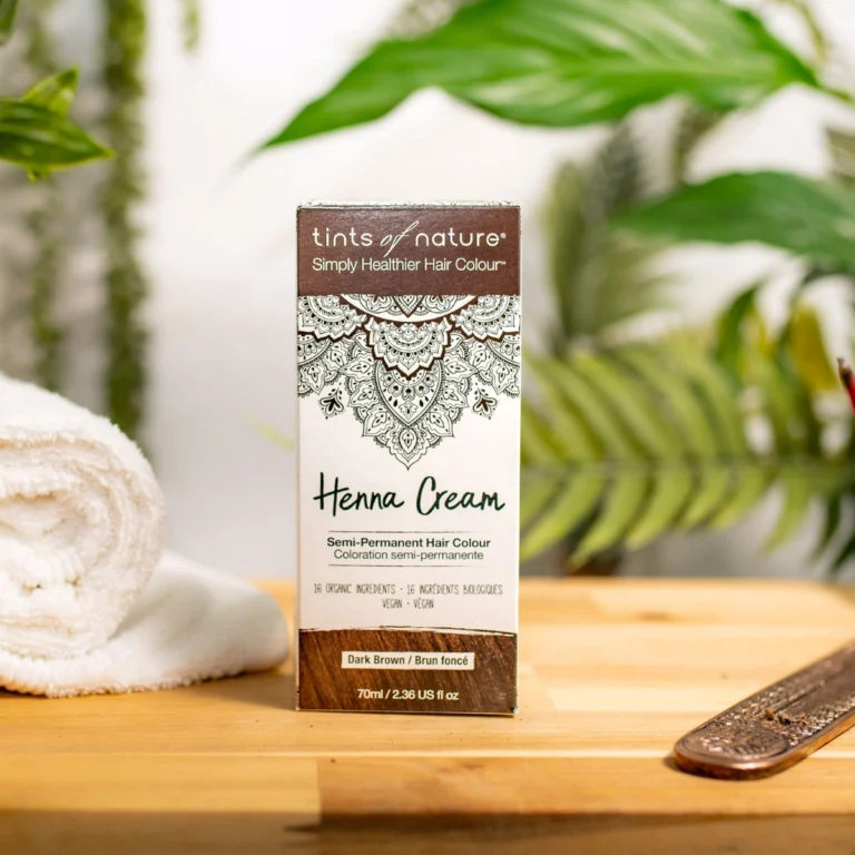 Pureday En æske Tints of Nature Henna Cream Dark Brown - 70 ml udstillet på en træoverflade med en plante og et håndklæde i baggrunden, perfekt til naturlig velvære.