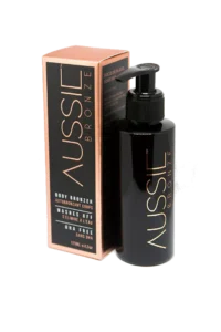 Pureday En flaske Aussie Bronze - Øjeblikkelig solbrun kropsbronzer ved siden af dens orange og sorte emballage mod en grå baggrund. Flasken har en sort pumpedispenser og indeholder naturlige ingredienser.