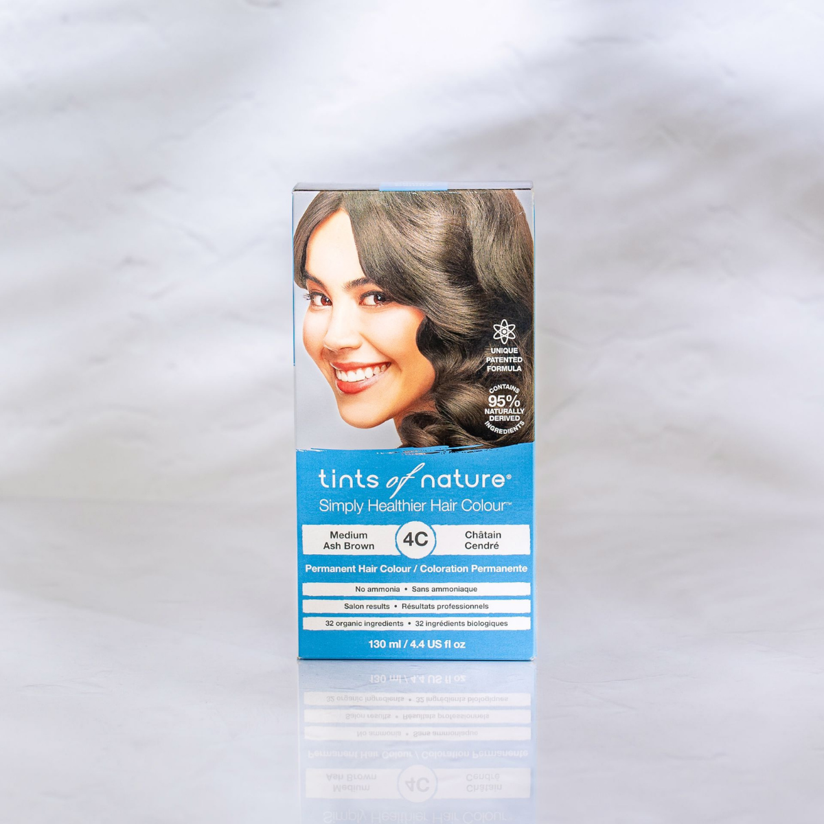En æske Økologisk hårfarve - Tints of Nature 4C Medium Ash 130 ml med et kvindeansigt på, der fremmer naturlig skønhed for velvære og helbred.
