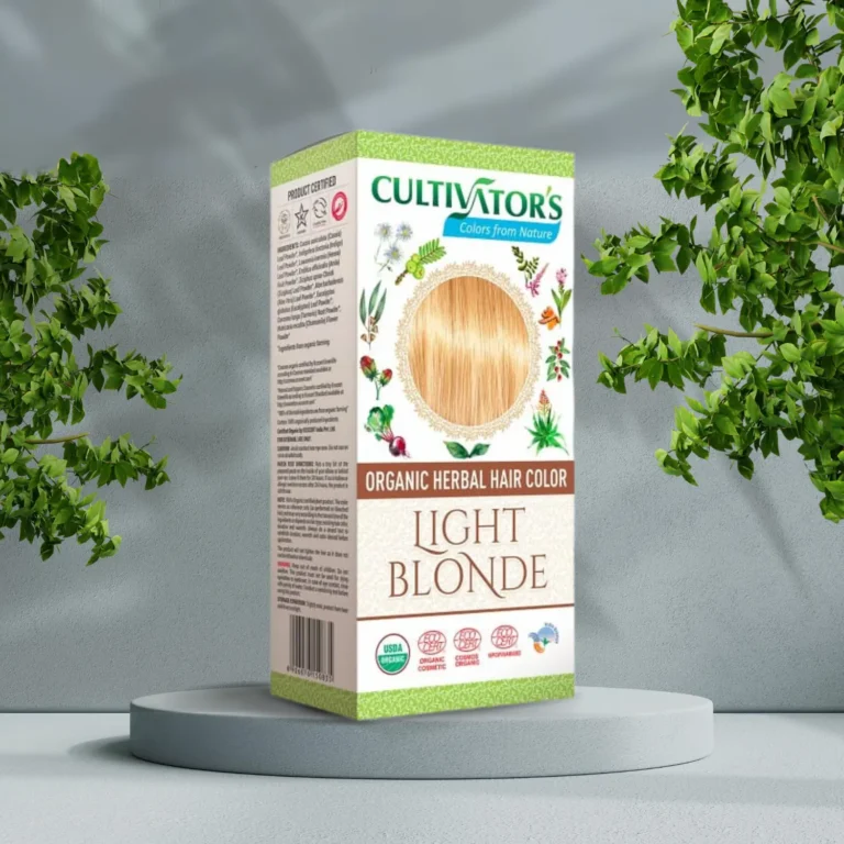 Pureday En æske Cultivators Henna hårfarve Light Blonde 100g står på en piedestal, omgivet af frodige grønne planter, med en naturlig lysegrå baggrund.