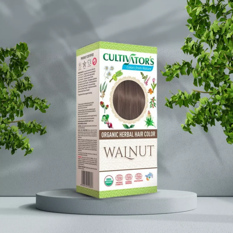 Pureday En kasse med Cultivators Henna hårfarve i Walnut skygge står på en piedestal beliggende mellem grønne bladbuske, med etiketten, der viser naturlige ingredienser og certificeringer, perfekt til dem, der søger nat