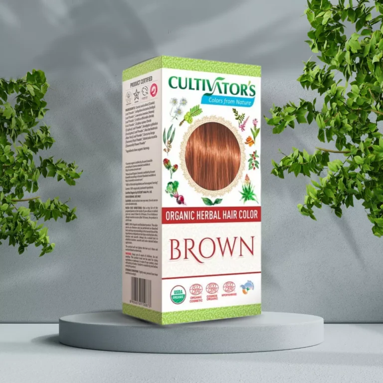 Pureday En æske med Cultivators Henna hårfarve Brown 100g står på en udstillingssokkel, omgivet af frodigt grønt, med detaljerede produktbeskrivelser og pureday-etiketter
