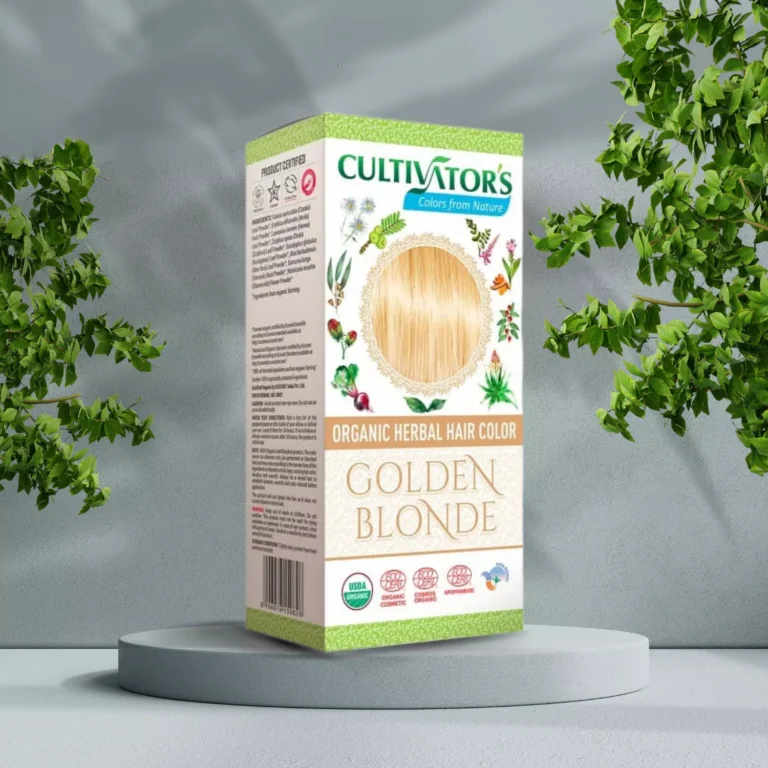 Pureday En æske med Cultivators Henna hårfarve Golden Blonde 100g placeret på en udstillingsstand, omgivet af grønne planter, med en grå tekstureret baggrund.