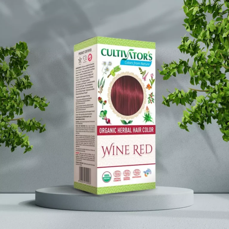 Pureday En kasse med "Cultivators Henna hårfarve Wine Red 100g" står på en piedestal med en grå baggrund og grønne planter omkring, og viser sin økologi-certificering.