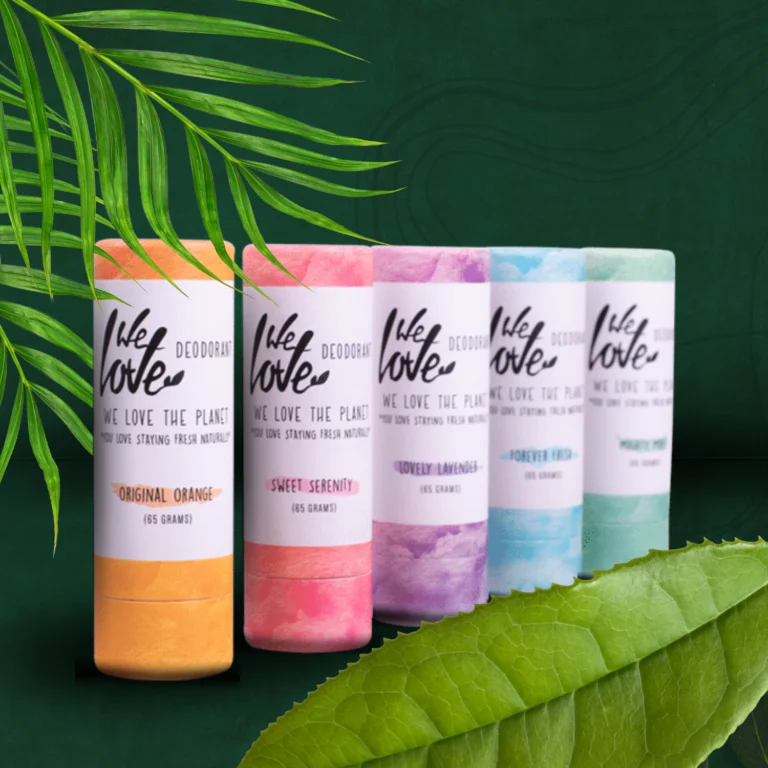 Pureday Fem farverige We Love The Planet Deodorant - Naturlig deodorantrør vises på række på en grøn baggrund med palmeblade på toppen og bunden, hvilket giver et naturligt valg til din.