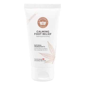 Pureday En tube Calming Foot Relief creme med en etiket med naturlige ingredienser og designet til nærende og beroligende, detaljeret med en fjerillustration. Cremen er mærket som "Pureday".