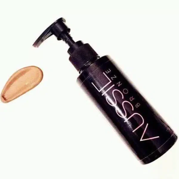 Pureday En sort flaske med en pumpedispenser mærket "Aussie Bronze - Instant tanning" på en hvid baggrund med en klat beige lotion spildt ved siden af.