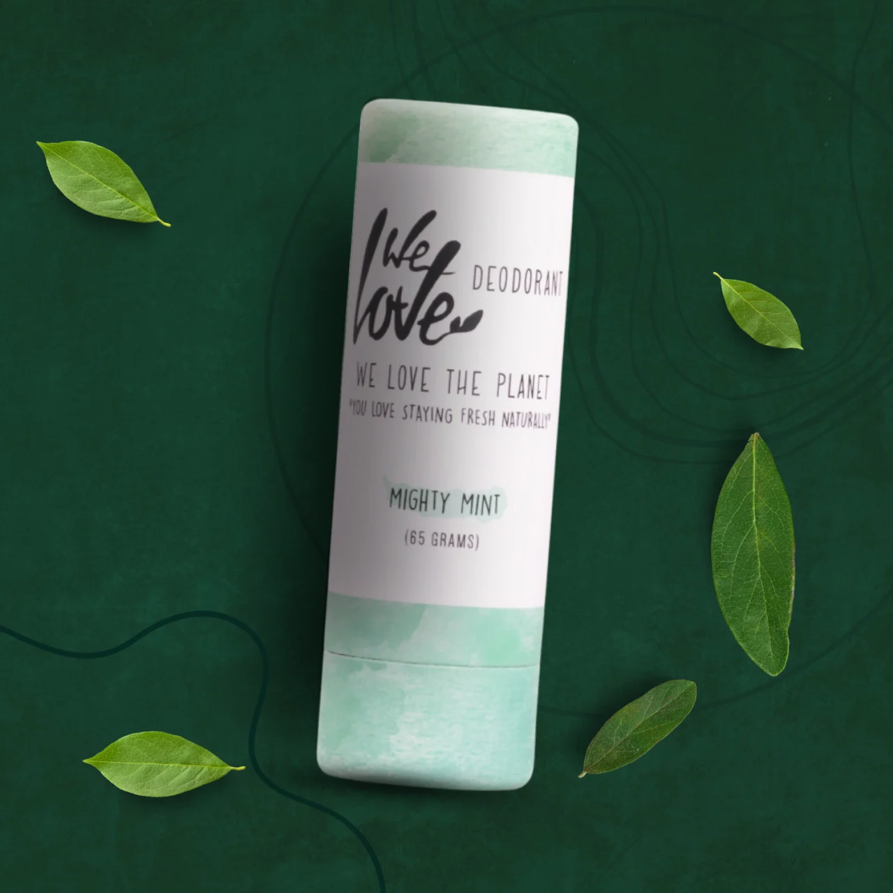 En tube Økologisk deodorantstift - Mighty Mint 65g med naturlige grønne blade omkring.