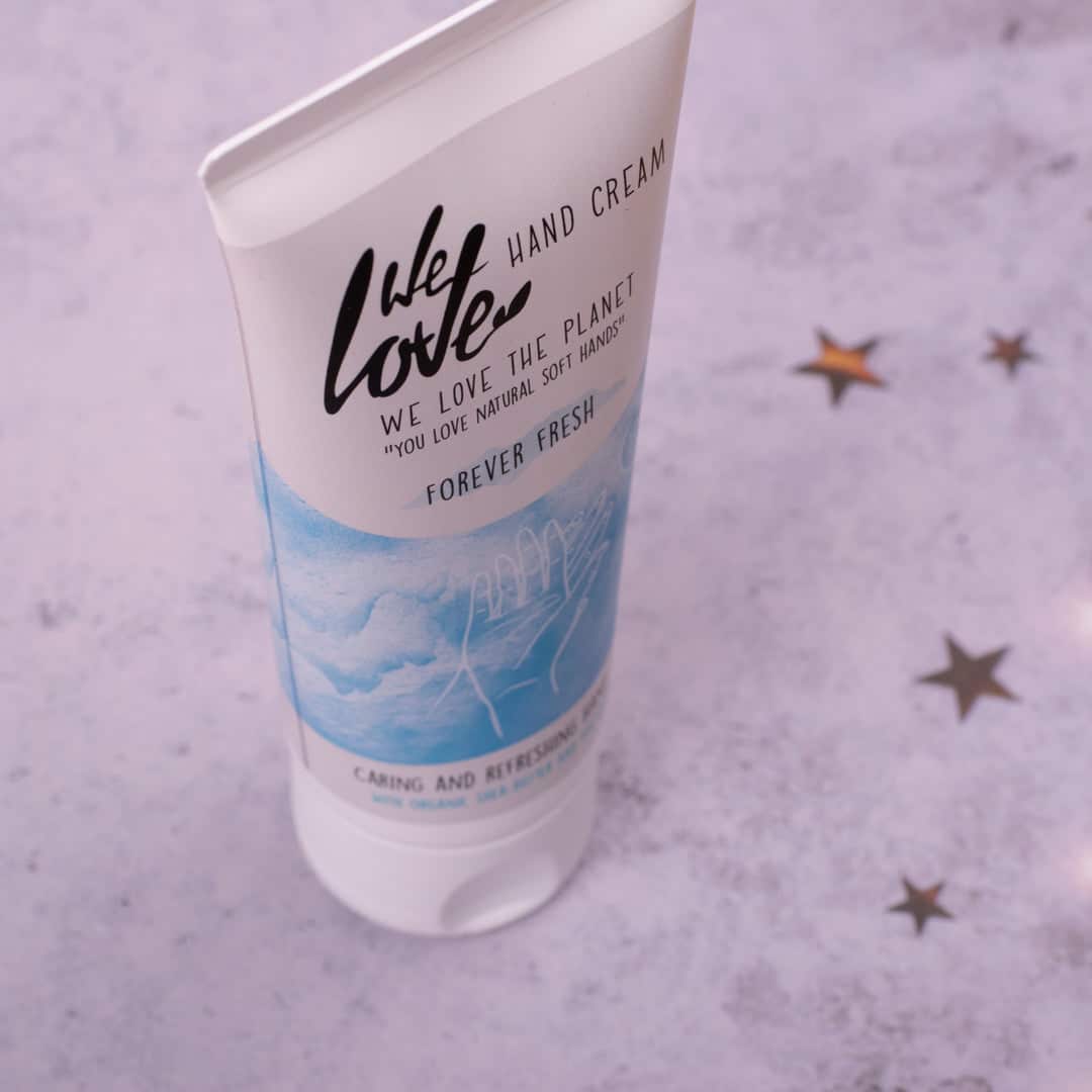 En tube med Økologisk Håndcreme - We Love the Planet - Naturlig håndcreme 75ml dekoreret med stjerner.